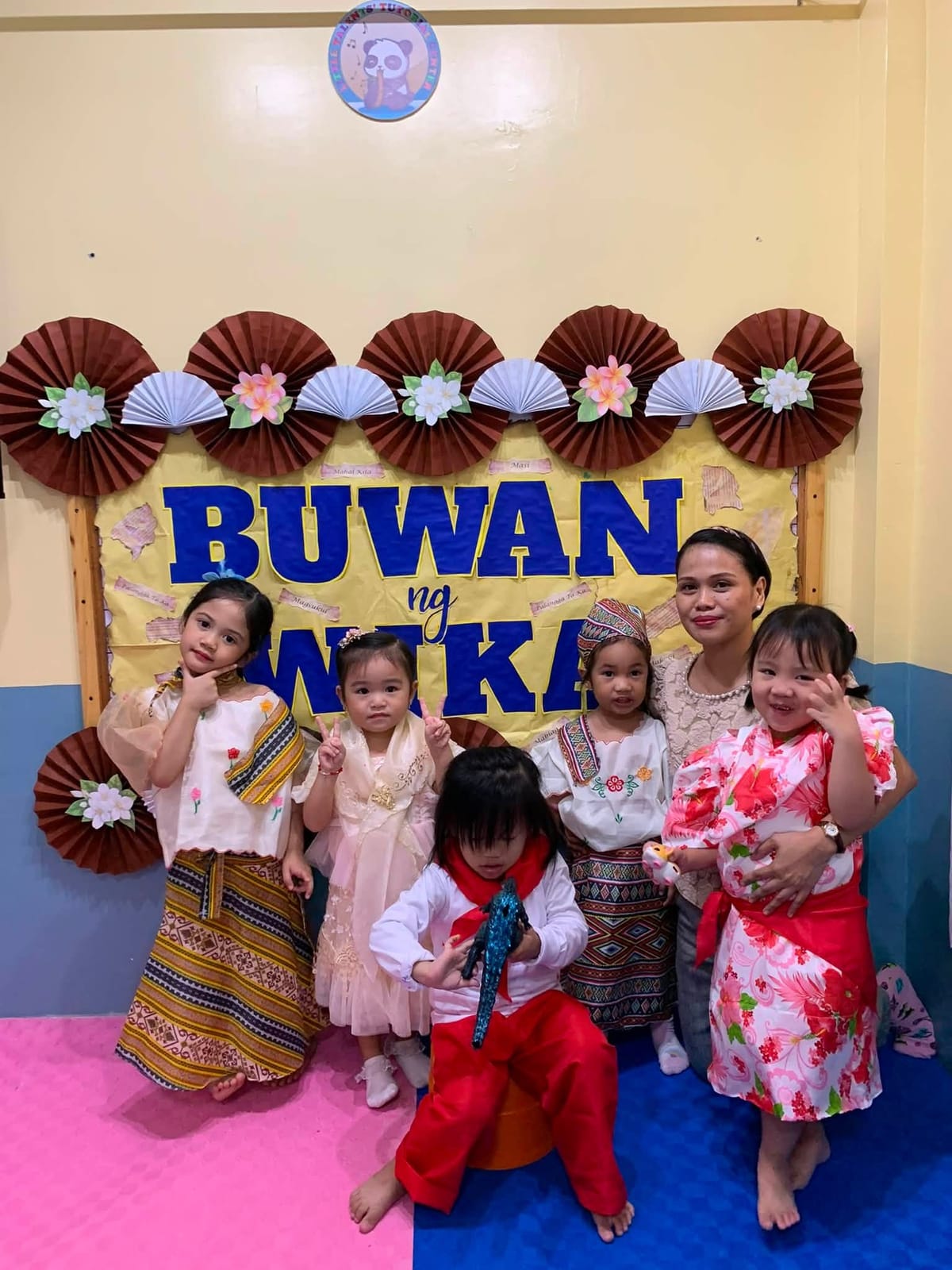 Children and teacher posing together after a celebration