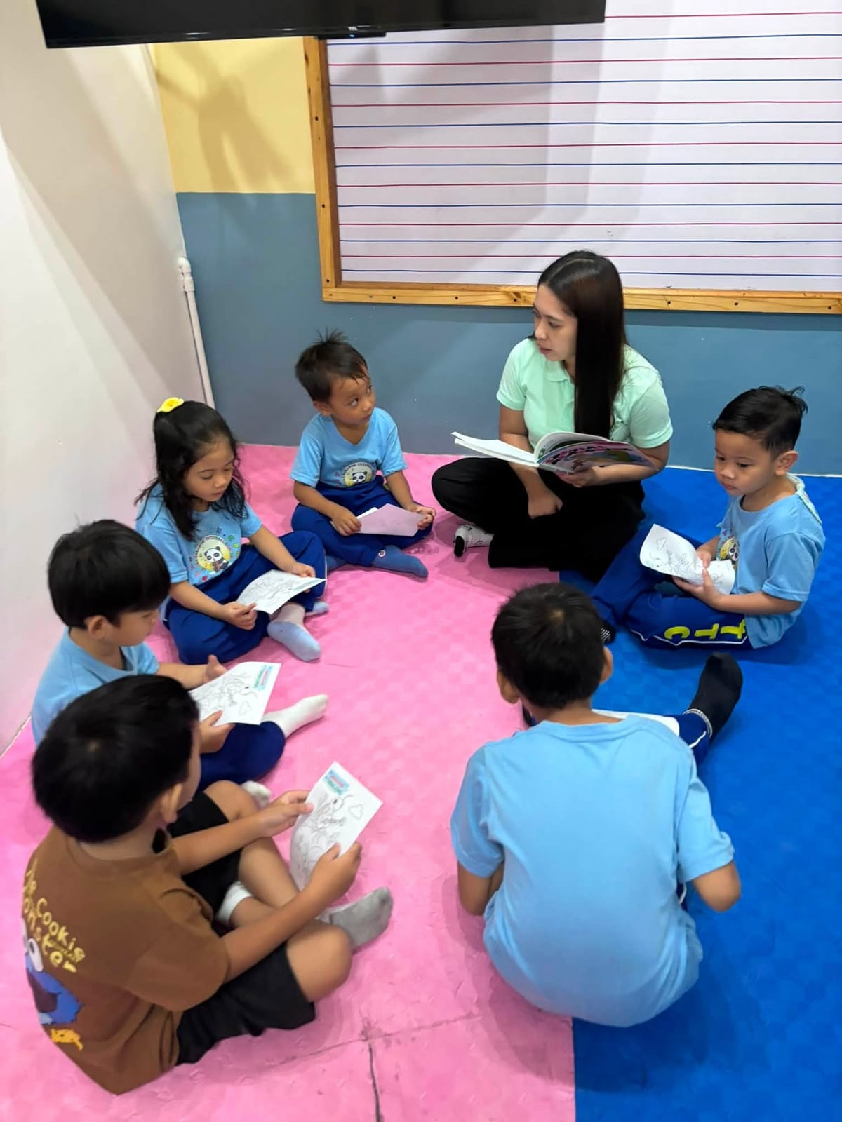Teacher reading to a circle of playschool children at LTTC