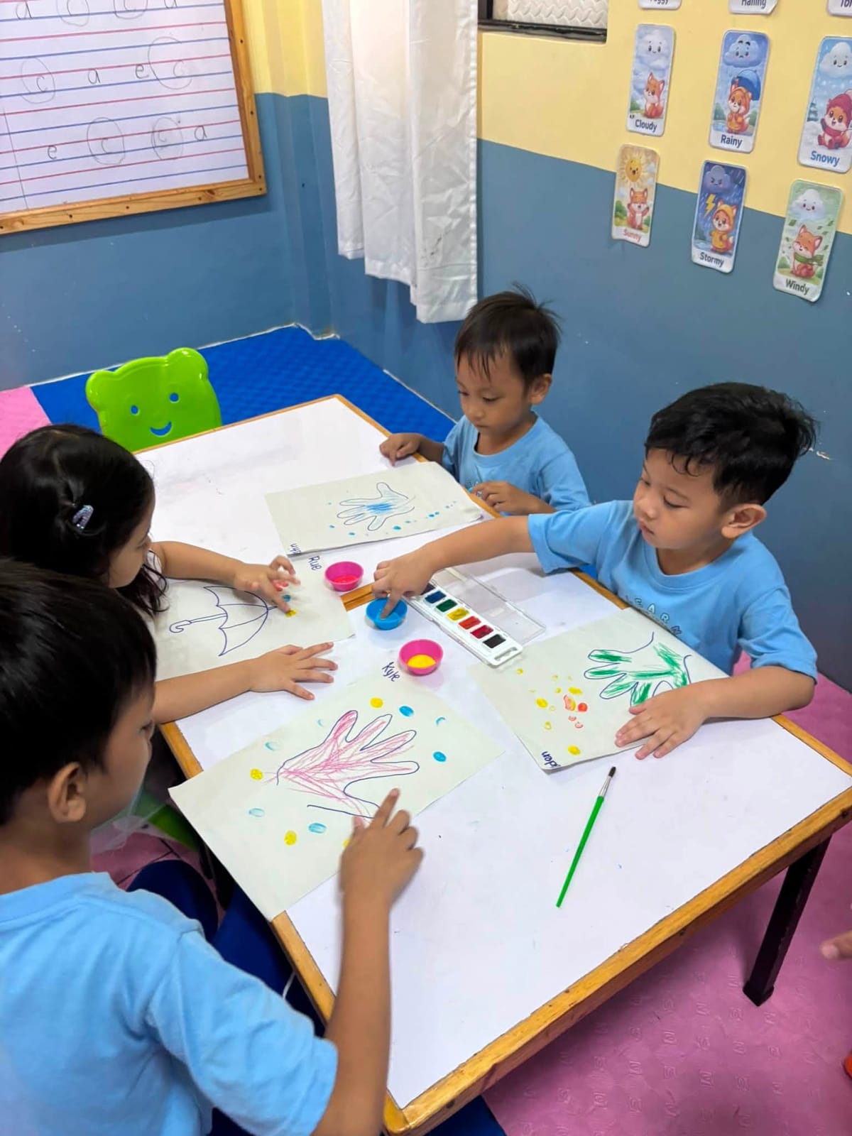 Children painting together at a classroom table